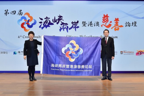 澳門基金會行政委員會委員區榮智向中國慈善聯合會執行秘書長彭建梅移交論壇會旗