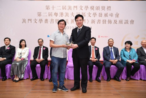 中央人民政府駐澳特區聯絡辦公室薛曉峰副主任向中篇小說優秀奬得主李宇樑頒奬